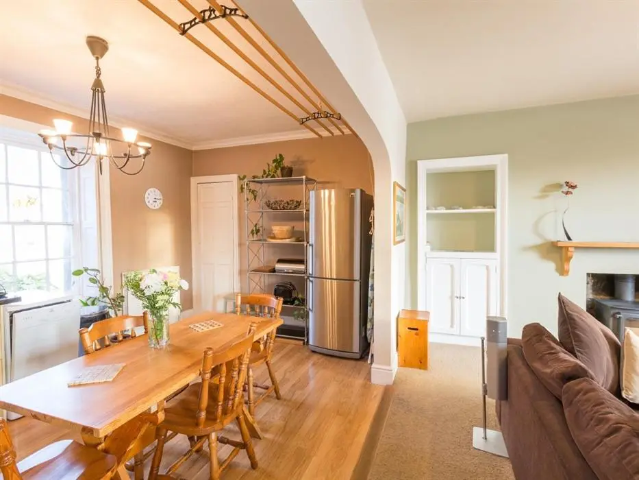 a kitchen and dining room with a table and a refrigerator at River Cottage in Inverness
