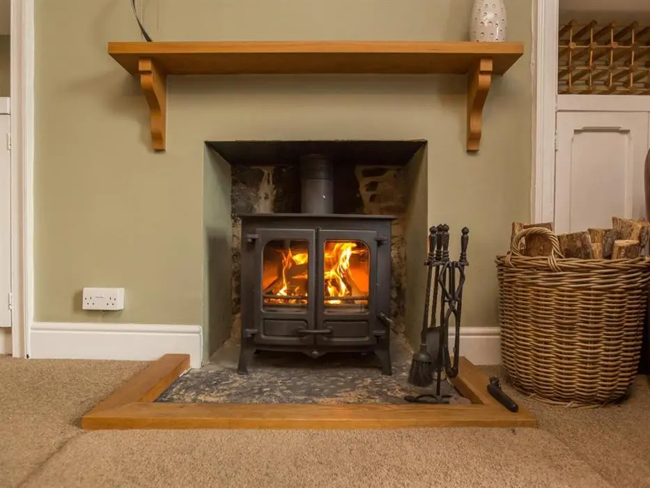 a fireplace in a living room with a stove at River Cottage in Inverness