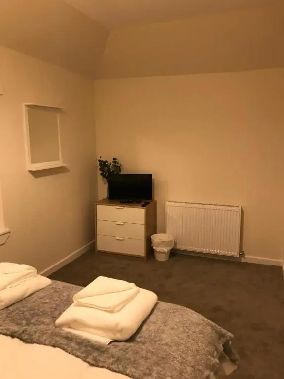 a bedroom with a bed and a tv on a dresser at 2 Lower Kessock Street in Inverness