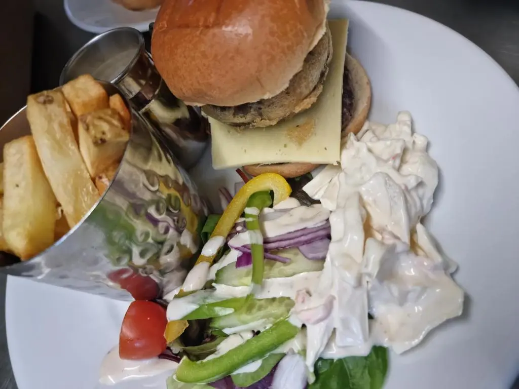 a plate of food with a sandwich and salad at Grampian Hotel in Keith
