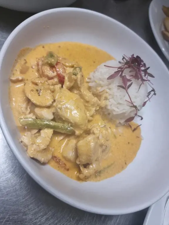 a white bowl of food with chicken and rice at Grampian Hotel in Keith