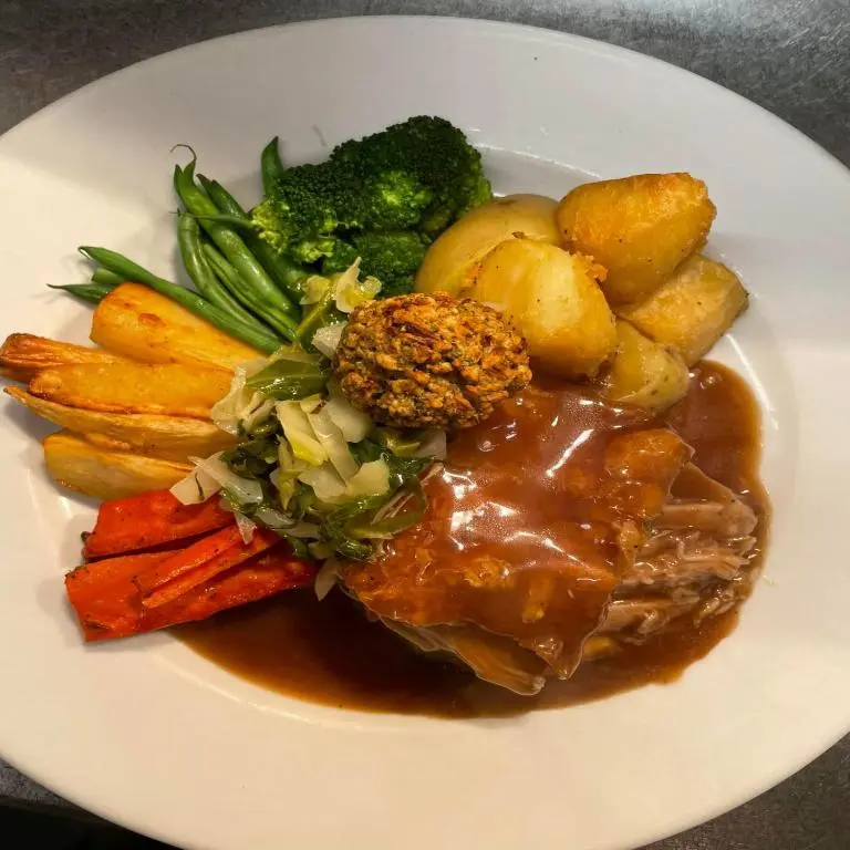 a plate of food with meat and vegetables and gravy at Firth Hotel & Restaurant in Lossiemouth
