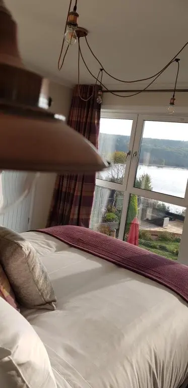 a bedroom with a bed with a large window at Airanloch Bed & Breakfast,Loch Ness, Adult Only in Lochend