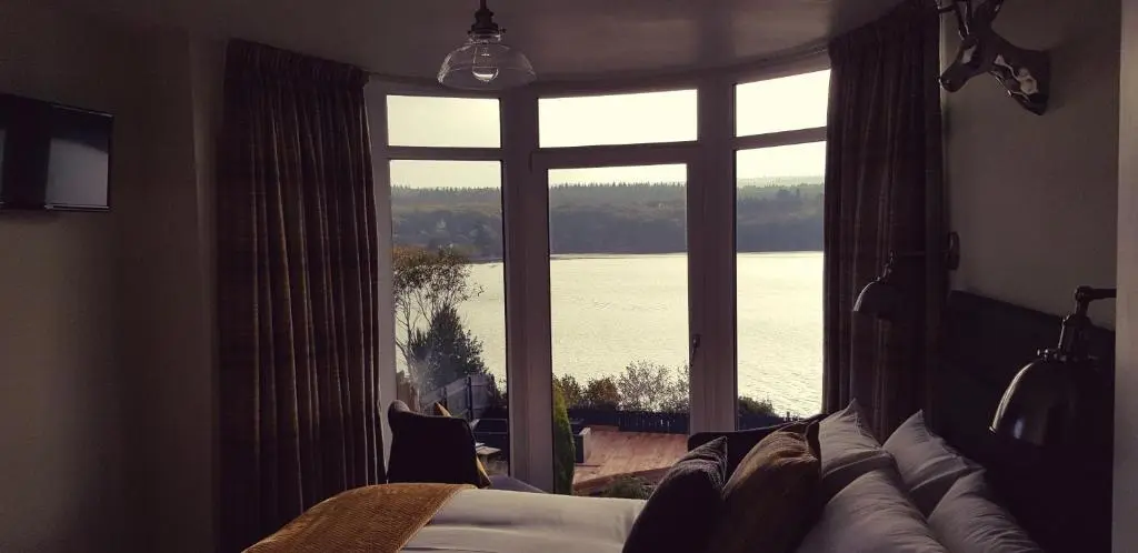 a bedroom with a large window with a view of the snow at Airanloch Bed & Breakfast,Loch Ness, Adult Only in Lochend