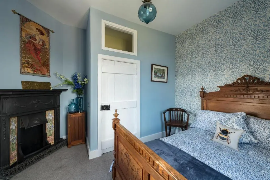 a bedroom with a bed and a fireplace at Evelix, The Old School House in Muir of Ord