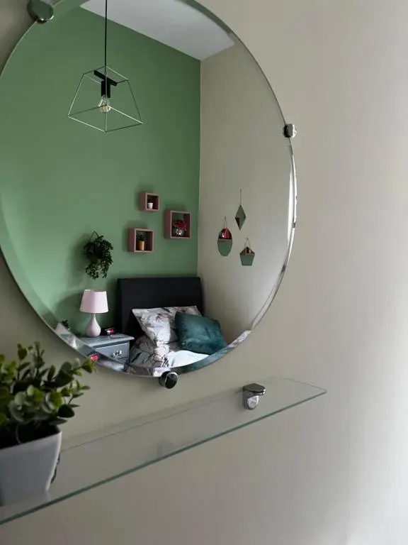 a bedroom with a circular mirror on the wall at The Sheriffs Lodge in Dingwall