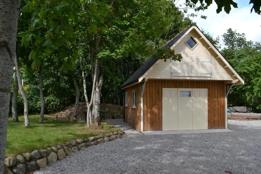 a garage with a large white garage door at Loch Ness Studio Blairbeg in Drumnadrochit
