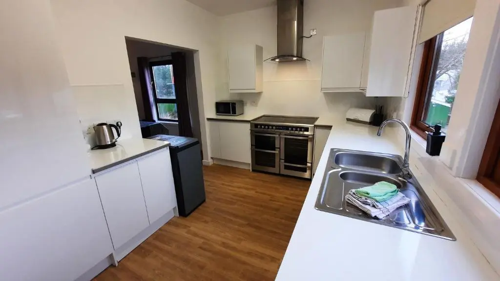 a small kitchen with a sink and a stove at Lagganlia Lodges and Camping Pods in Kincraig