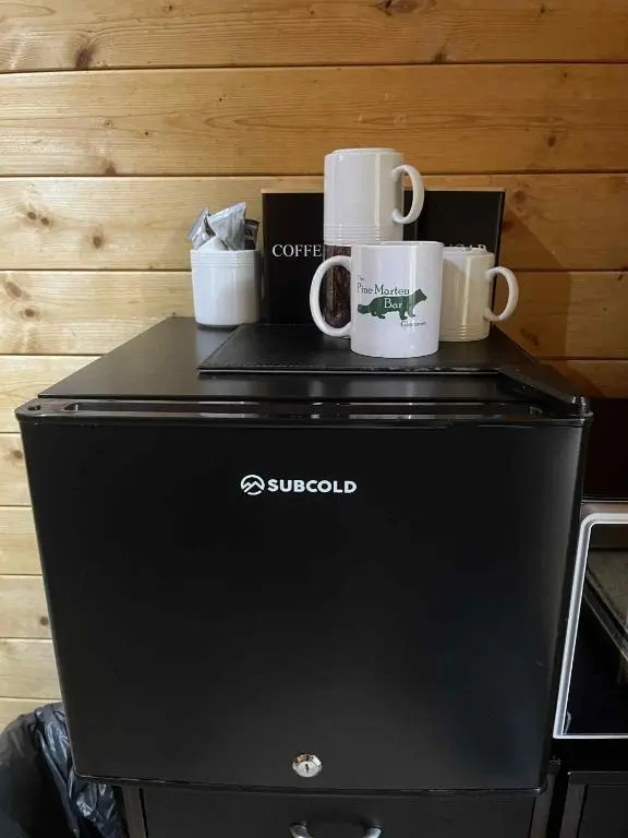 two coffee cups sitting on top of a dishwasher at Pine Marten Bar Glenmore Pods in Aviemore