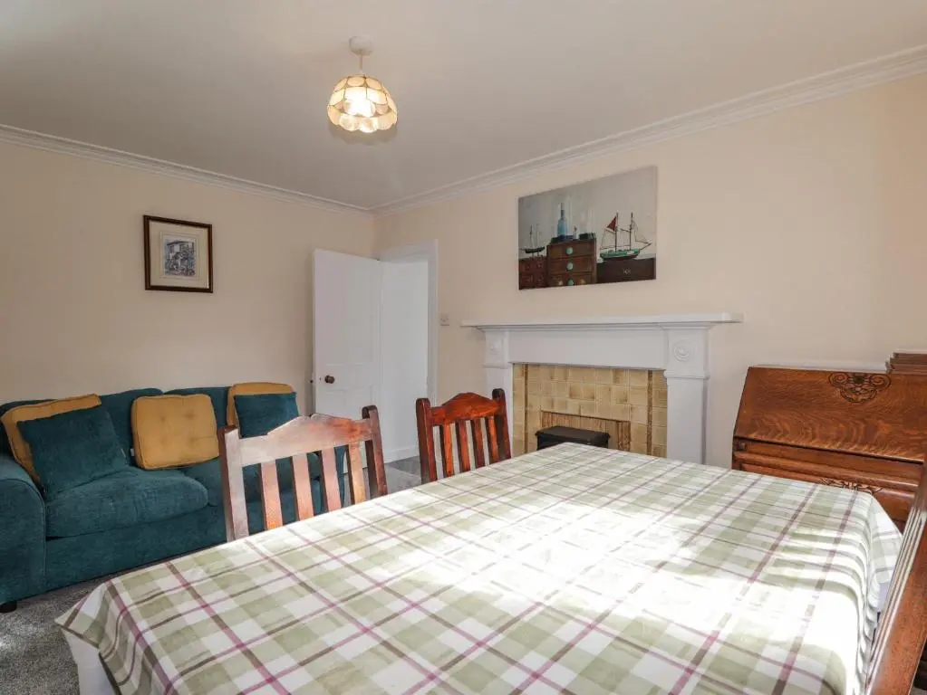 a bedroom with a bed and a couch and a fireplace at 19 Reidhaven Street in Banff