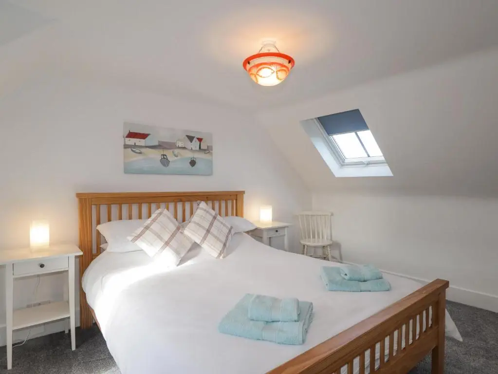 a bedroom with a white bed with two towels on it at 19 Reidhaven Street in Banff