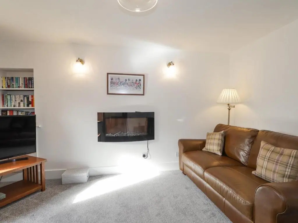 a living room with a couch and a fireplace at 19 Reidhaven Street in Banff