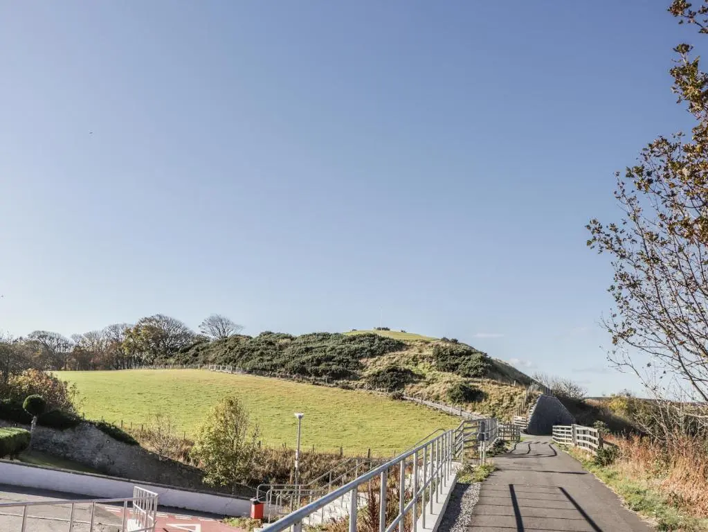 a road leading up to a hill with a fence at 83 Seatown in Buckie