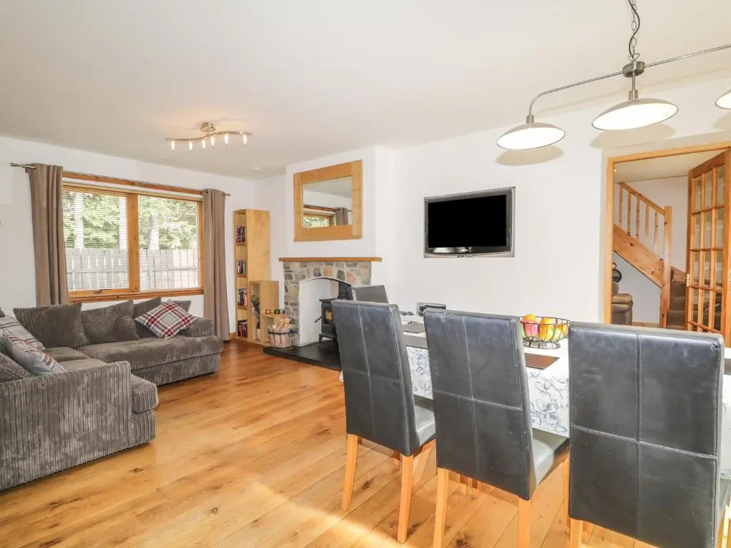 a living room with a couch and a table with chairs at Dolce Casa in Grantown on Spey