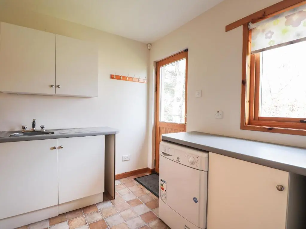 a kitchen with white cabinets and a sink at Millview in Boat of Garten