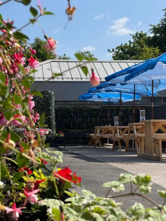 a group of picnic tables and blue umbrellas at Star Hotel Kingussie in Kingussie