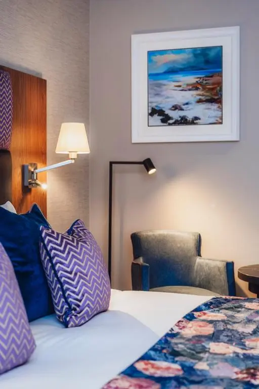 a hotel room with a bed and a chair at Star Hotel Kingussie in Kingussie