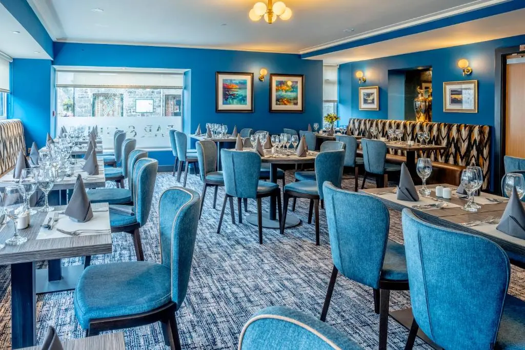 a restaurant with blue walls and tables and chairs at Star Hotel Kingussie in Kingussie