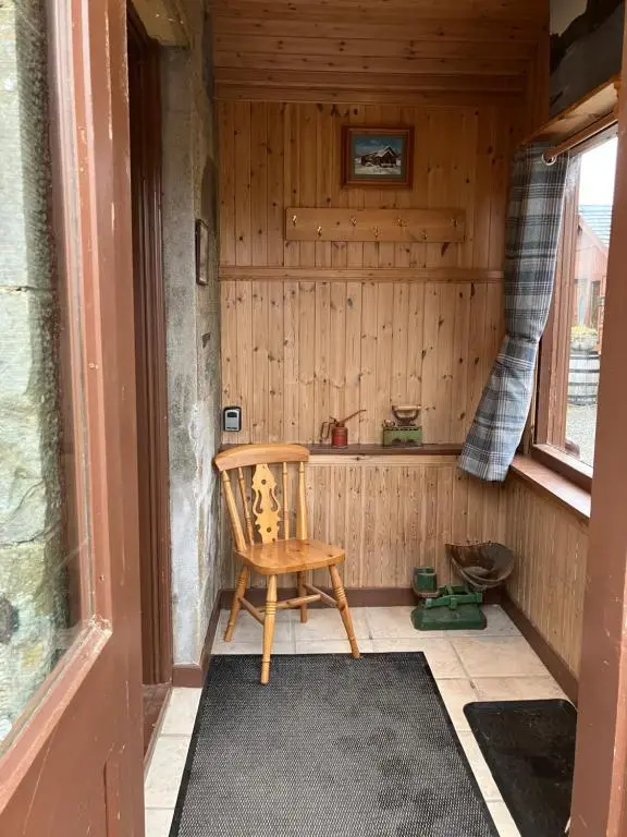 a wooden room with a chair and a window at Islay Cottage, Meadowside, Kincraig, near Kingussie in Kincraig