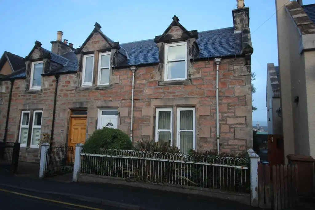 a brick house with a fence in front of it at 63 Argyle Street in Inverness