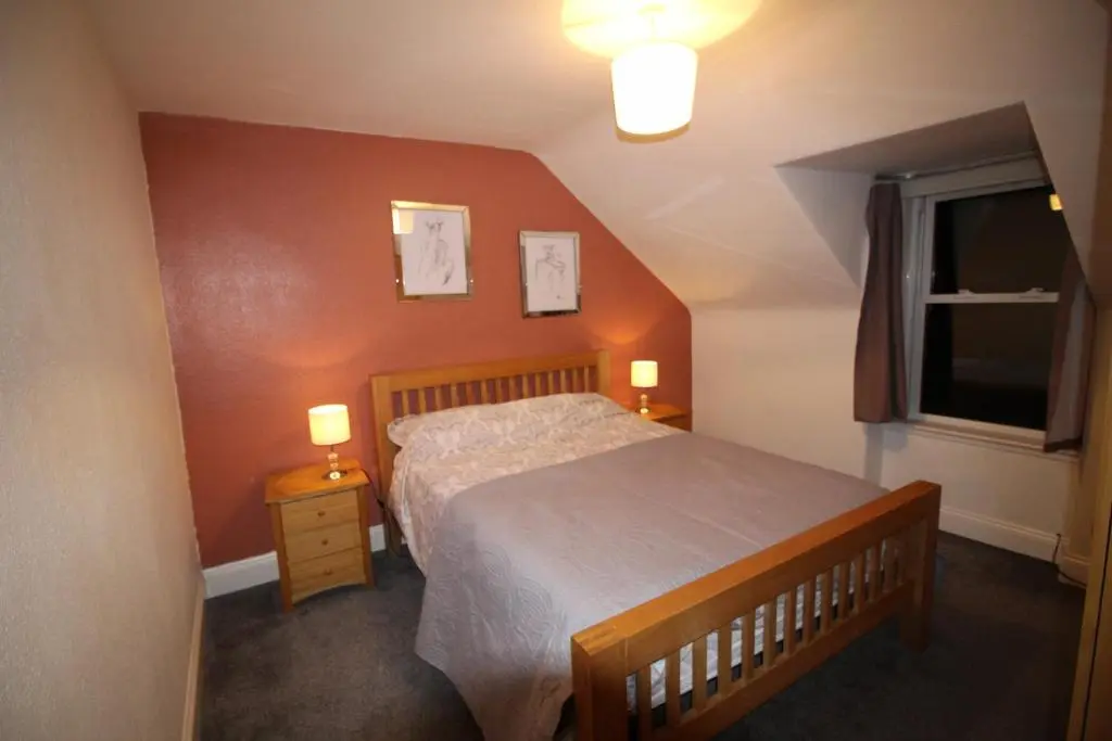 a small bedroom with a bed and a window at 63 Argyle Street in Inverness
