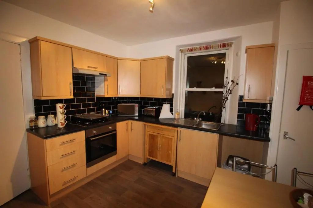 a kitchen with wooden cabinets and a counter top at 63 Argyle Street in Inverness