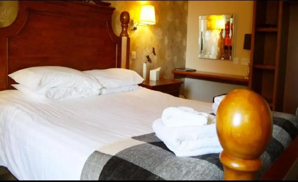 a hotel room with a bed with towels on it at Ban Car Hotel in Cairness