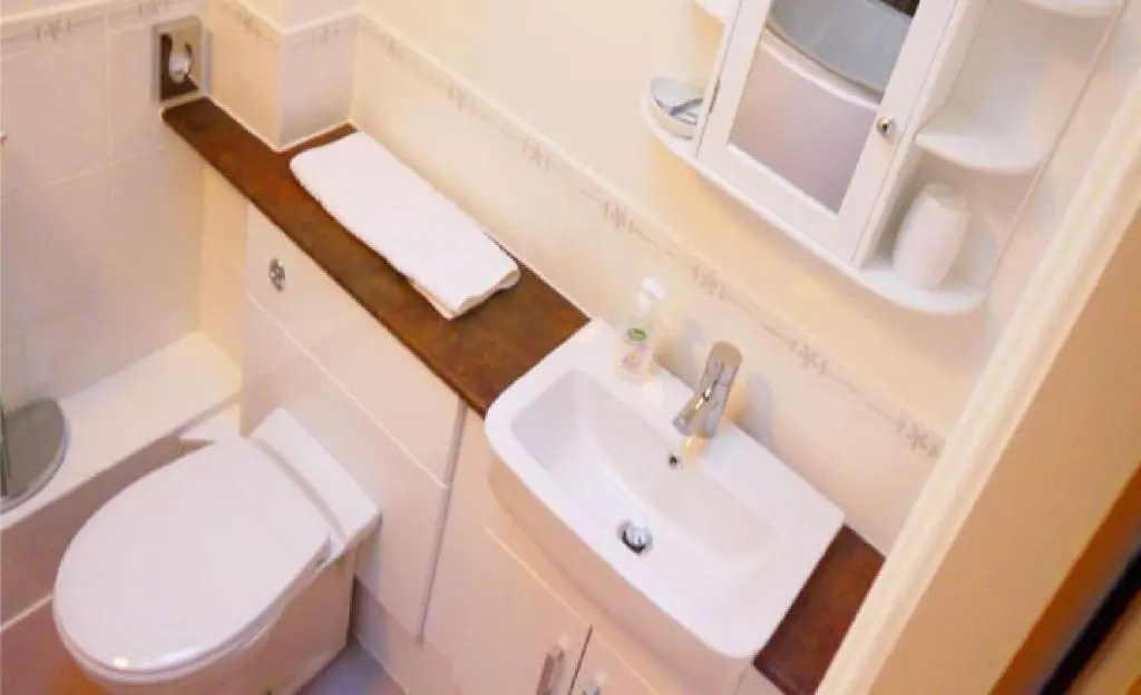 a small bathroom with a toilet and a sink at Ban Car Hotel in Cairness