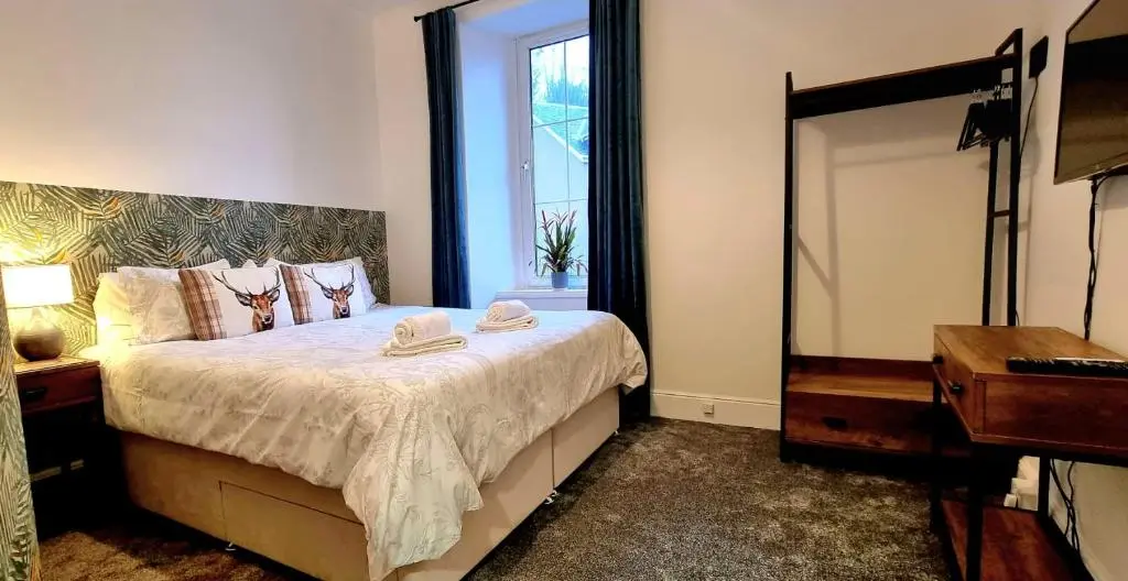 a bedroom with a bed with a mirror and a dresser at CHARMING VICTORIAN APARTMENT, close to centre in Inverness