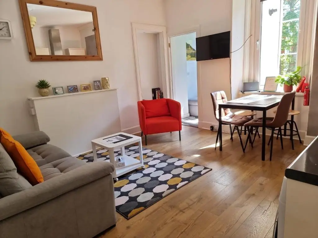 a living room with a couch and a table at CHARMING VICTORIAN APARTMENT, close to centre in Inverness