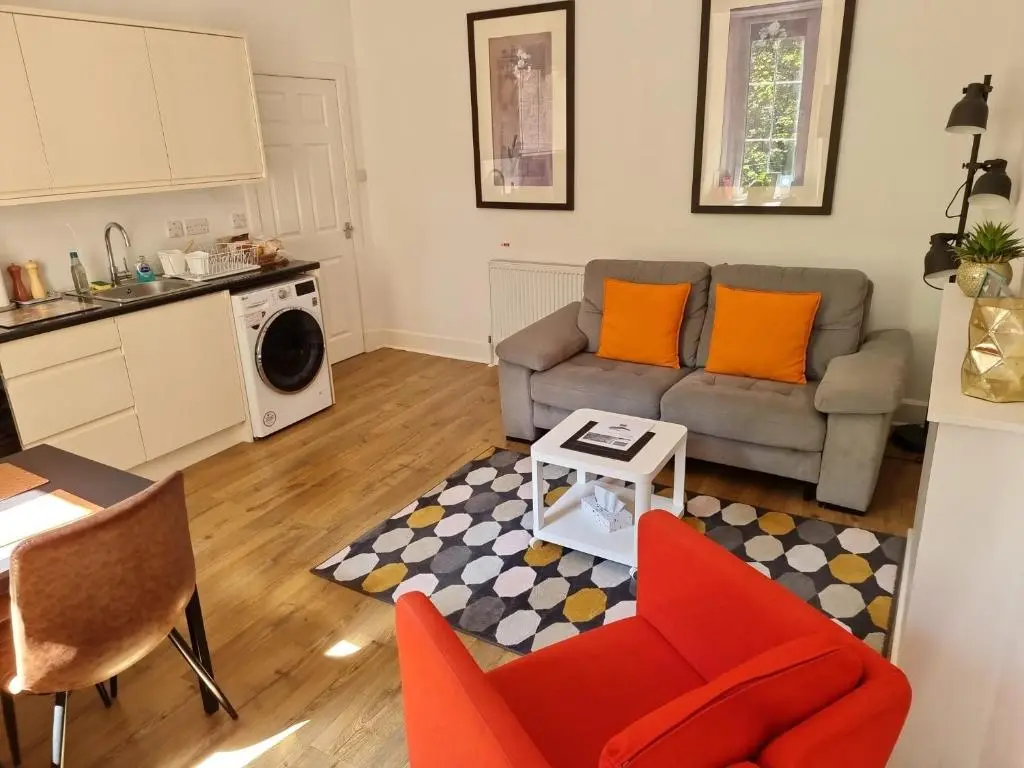 a living room with a couch and a table at CHARMING VICTORIAN APARTMENT, close to centre in Inverness