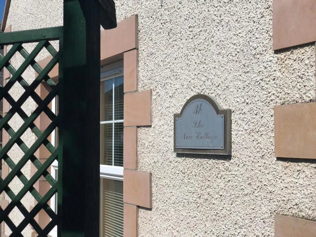 a sign on the side of a building at New Cottage 3 Bedroom Free Parking in Inverness