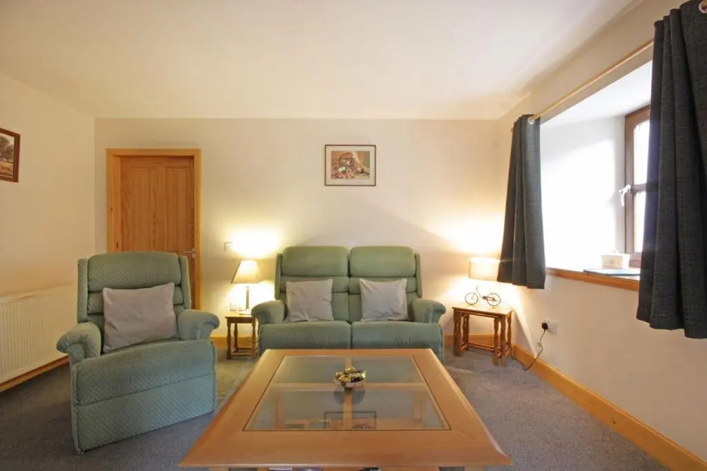 a living room with two chairs and a coffee table at Innes Street Apartments in Inverness