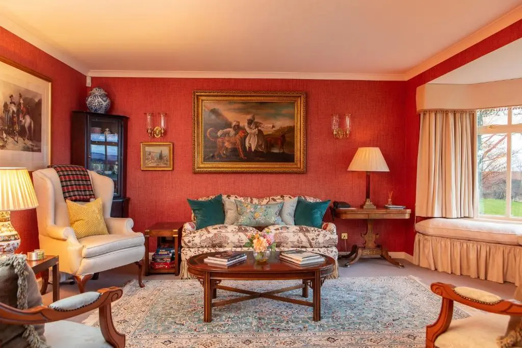 a red living room with a couch and a table at Balnagown Estates in Kildary