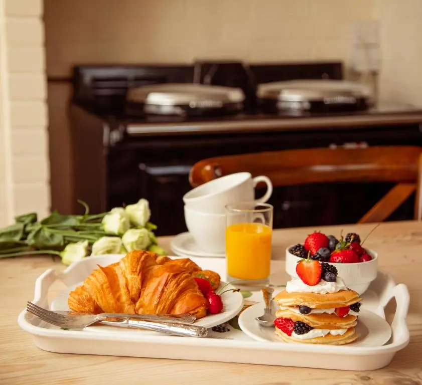 a breakfast tray with a croissant and fruit on a table at Balnagown Estates in Kildary