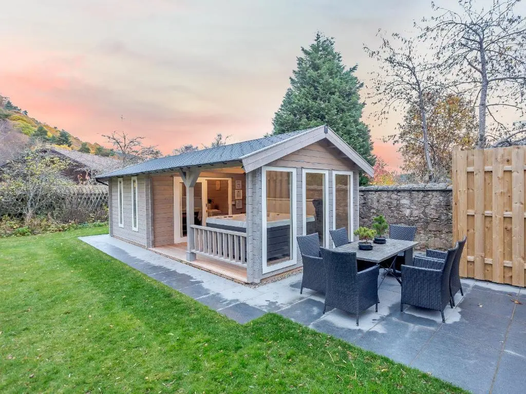 a shed with a table and chairs in a yard at Craigendarroch House in Ballater