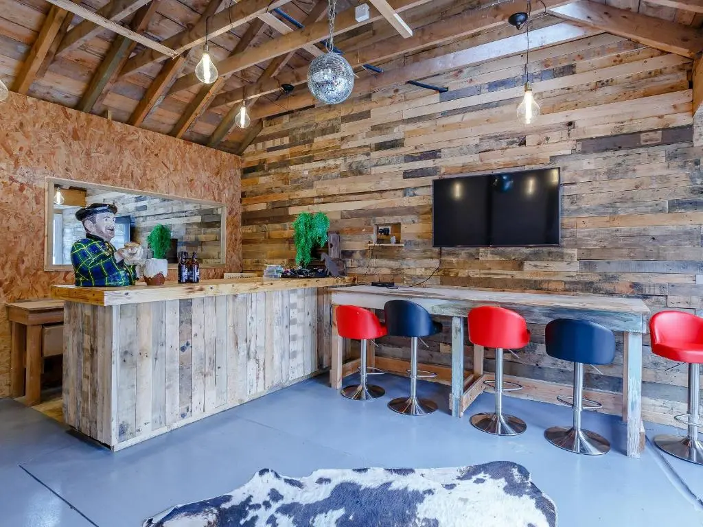 a bar in a room with wooden walls and redools at Craigendarroch House in Ballater