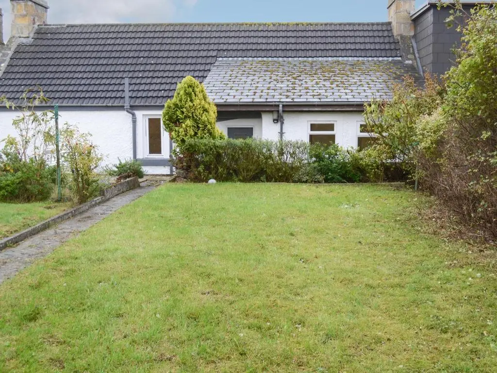 a white house with a yard in front of it at Fisher's Cottage in Balintore