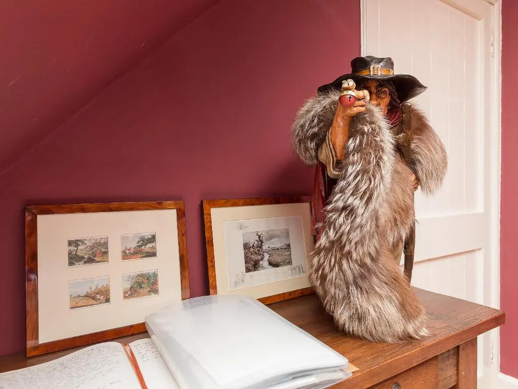 a person in a wolf costume sitting on a table at Big Barns Cottage in Backies