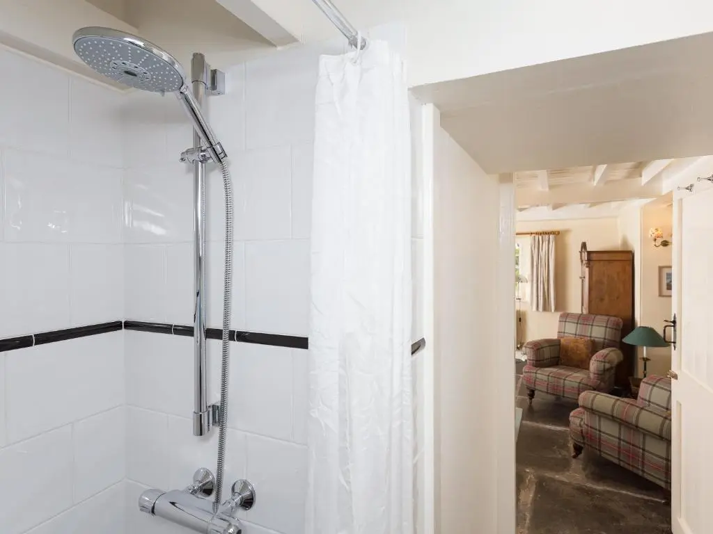 a bathroom with a shower with a shower curtain at Big Barns Cottage in Backies