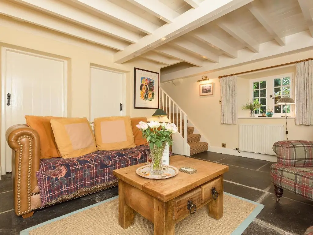 a living room with a couch and a table at Big Barns Cottage in Backies