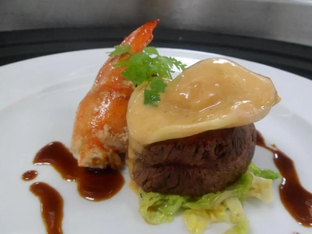 a plate of food with a hamburger and sauce at The Speyside Hotel and Restaurant in Grantown on Spey