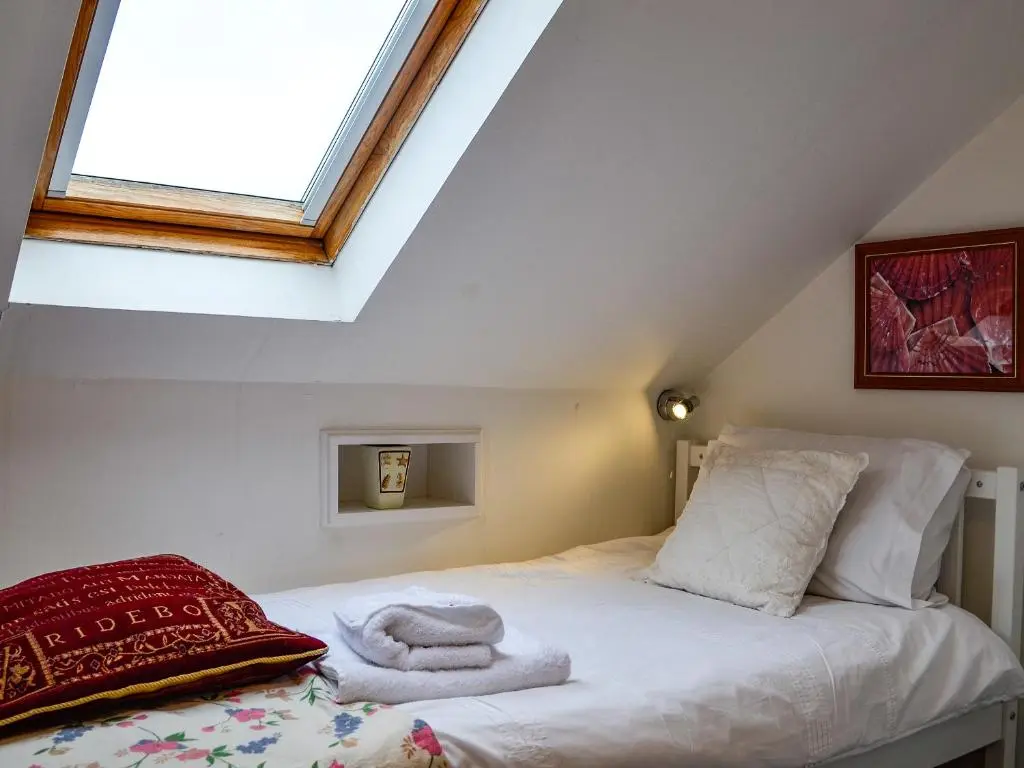 a bedroom with a bed with a window at Ruach in Gardenstown