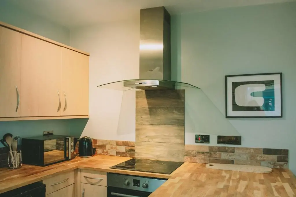 a kitchen with wooden cabinets and a stove at The Black Isle Retreat in Inverness