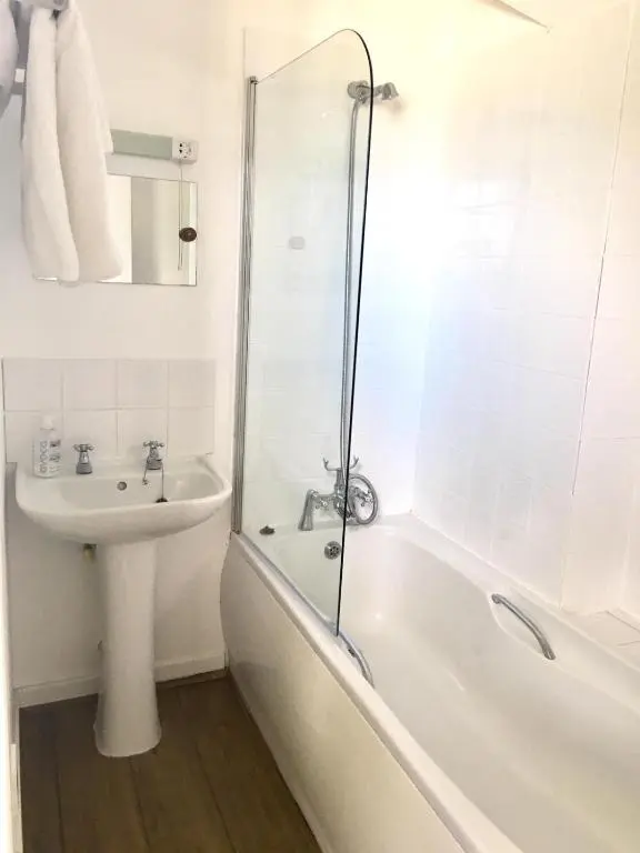 a bathroom with a tub and a sink and a shower at Whitebridge Hotel in Whitebridge