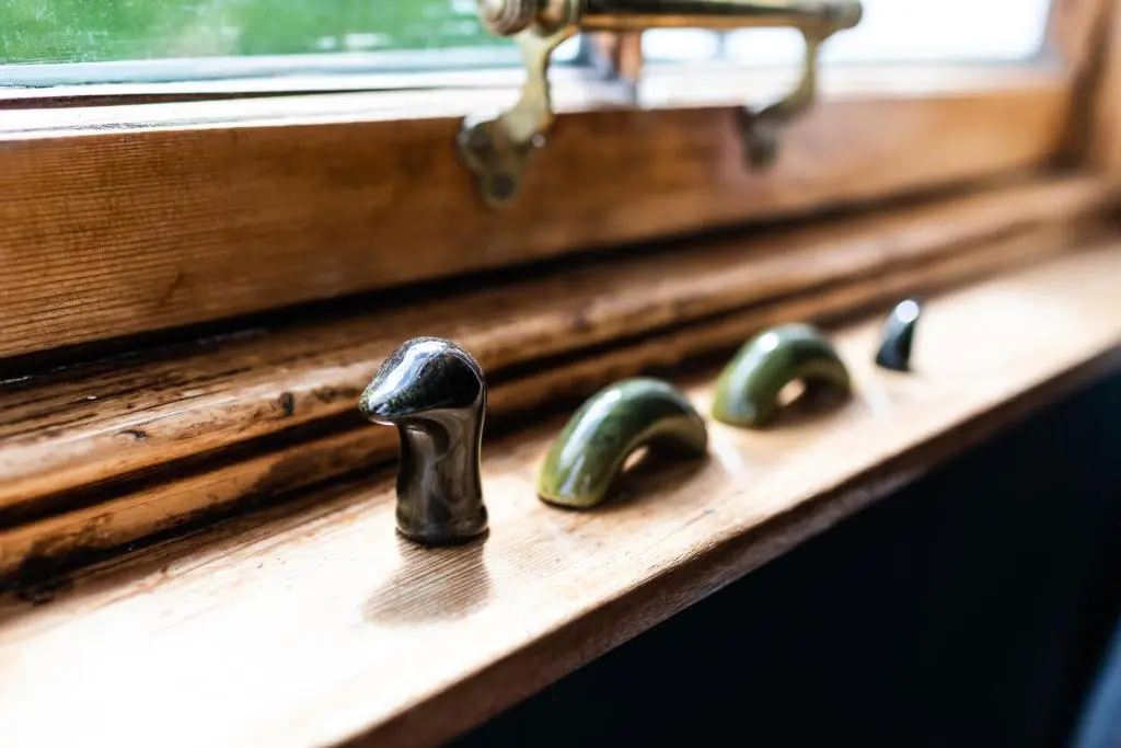 a wooden window sill with three metal knobs on it at Whitebridge Hotel in Whitebridge