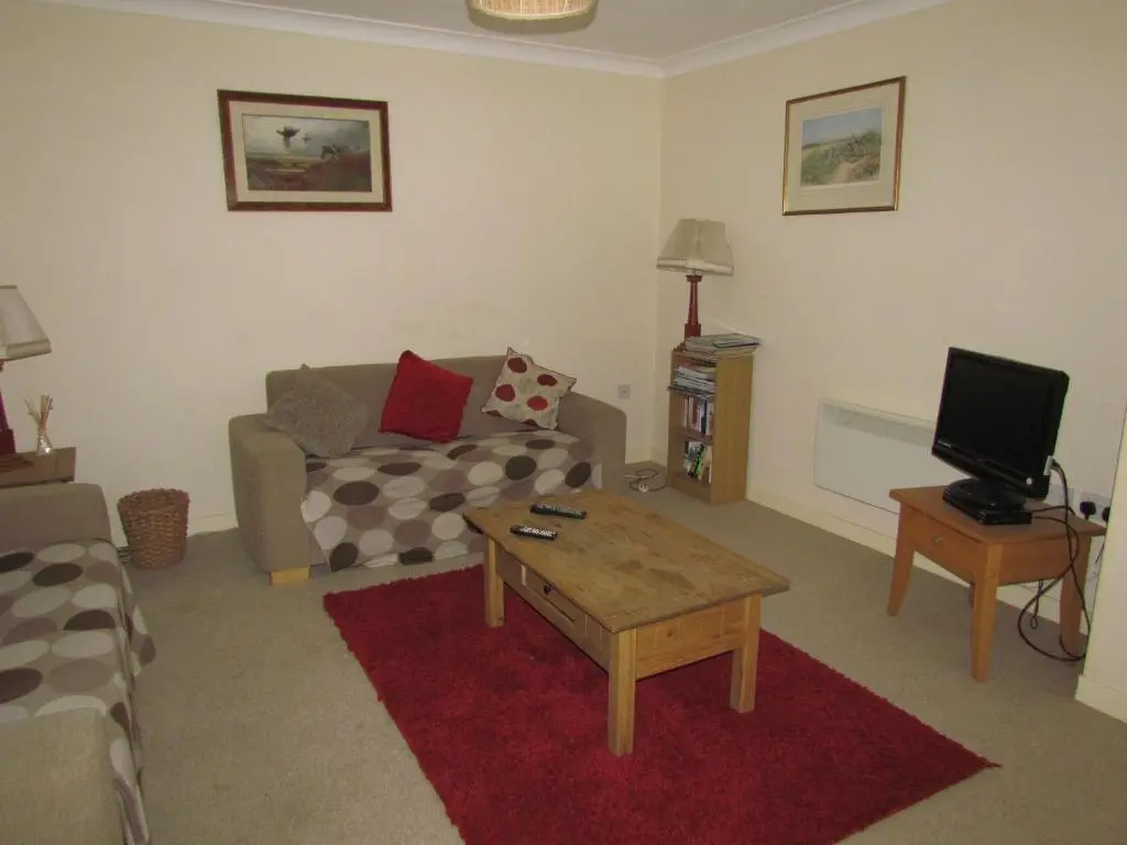 a living room with a couch and a coffee table at Altnaharra Hotel in Lairg