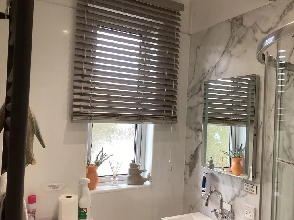 a bathroom with a window with blinds over a sink at Alba b & b in Inverness