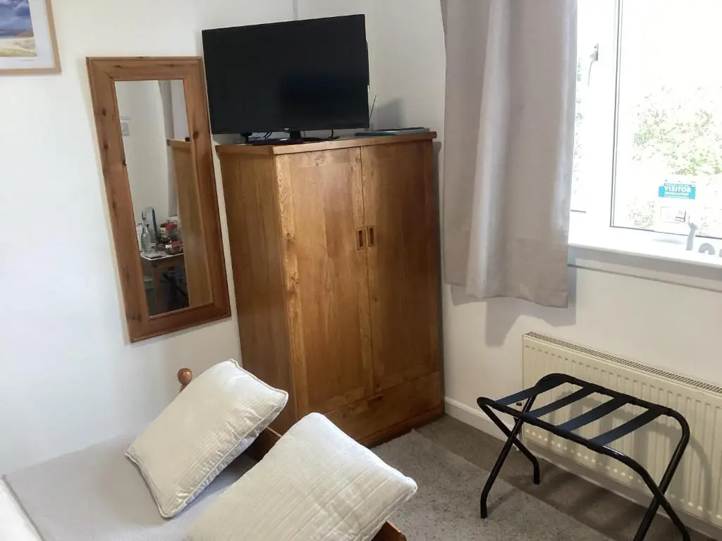 a living room with a tv on top of a wooden cabinet at Alba b & b in Inverness