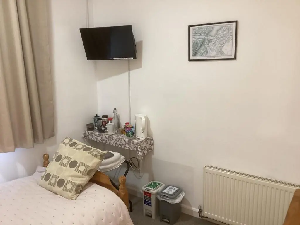 a bedroom with a bed and a television on the wall at Alba b & b in Inverness
